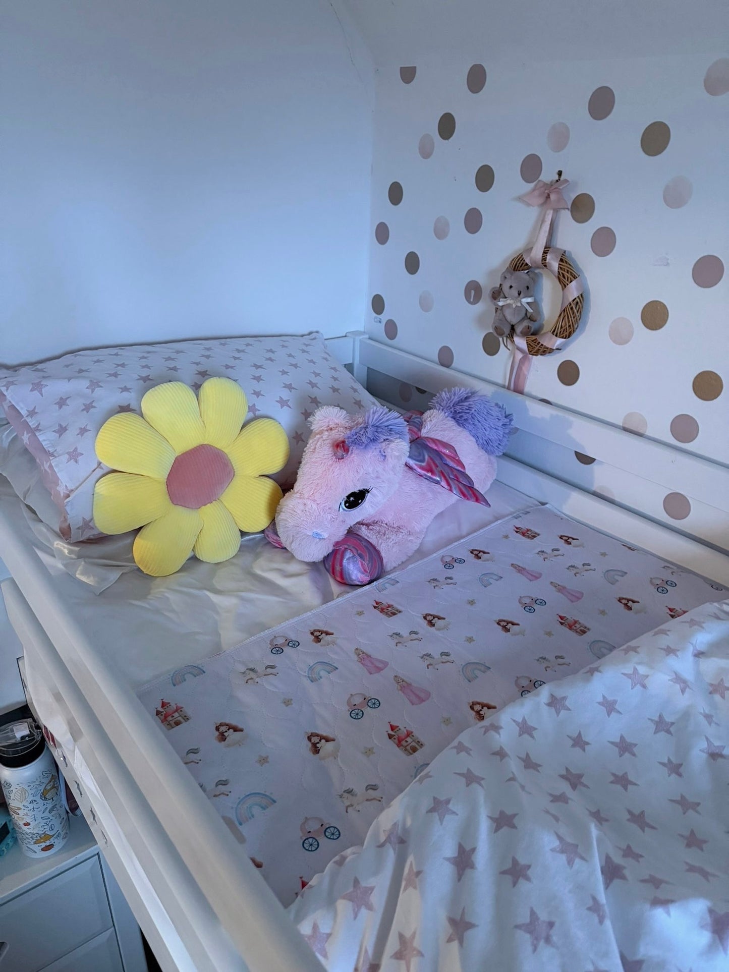 Single Bed with a unicorn plush toy and yellow flower decoration against a polka dot wall with a Quiet Kingdom Mattress Bed Sheet Protector